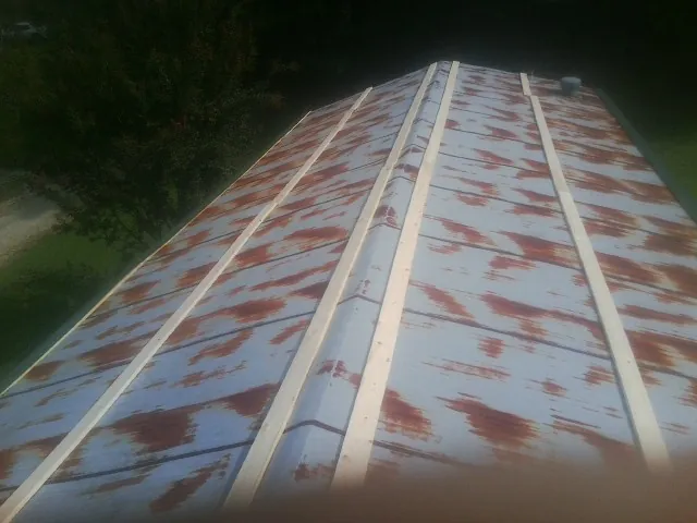 Rusted metal roof panels with new wood purlins before replacement — Storm Damage Roof Repair in Neenah by Roofing Brothers