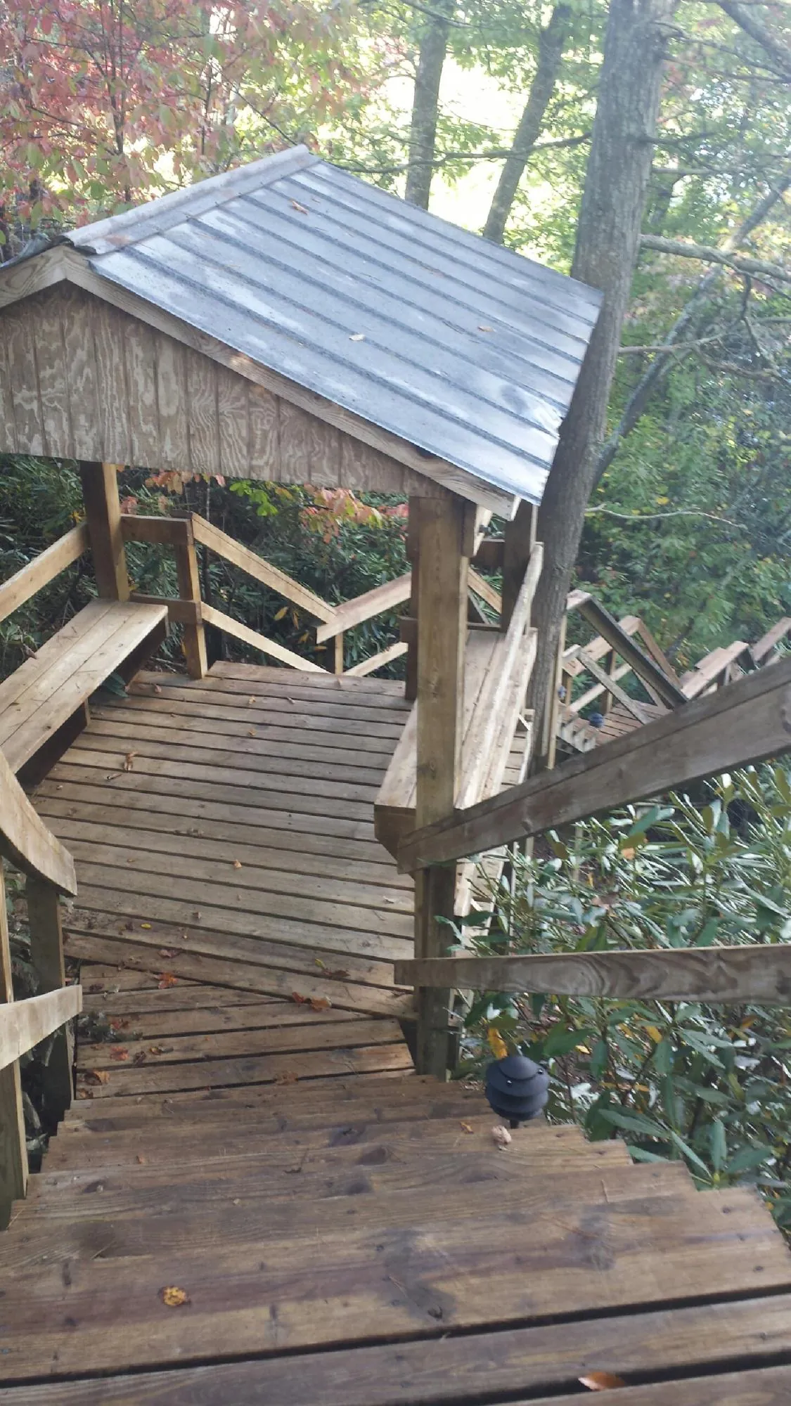 Metal roofed shelter over wooden steps on a wooded walkway — Skylight Repair & Installation work by our crew in Neenah