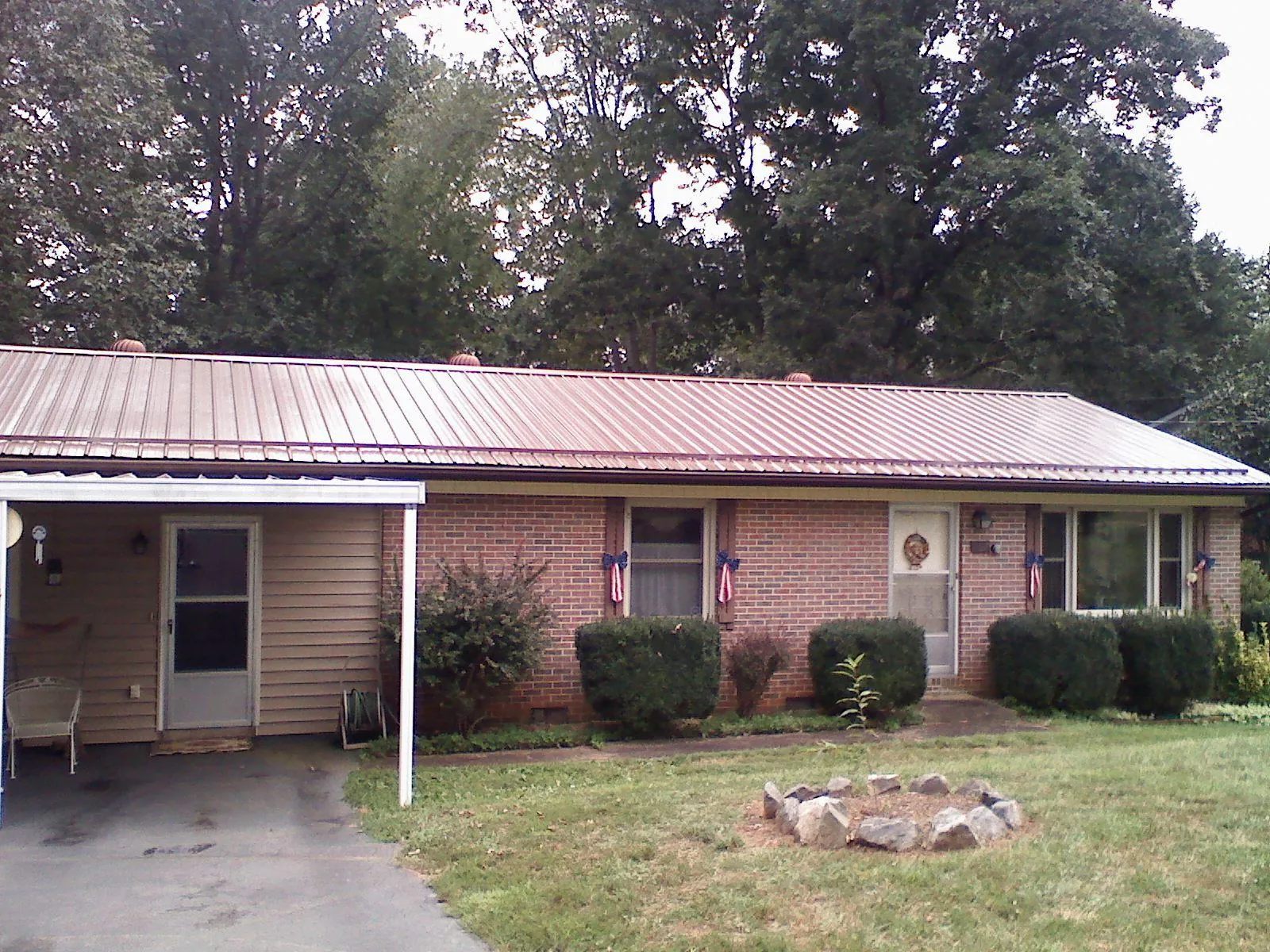 Bronze metal roof and carport on a brick ranch home — Roof Repair work by our crew in Neenah